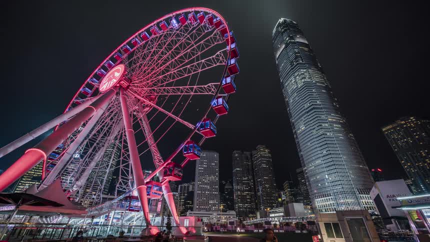 A ferris wheel with building and skyscrapers in the background