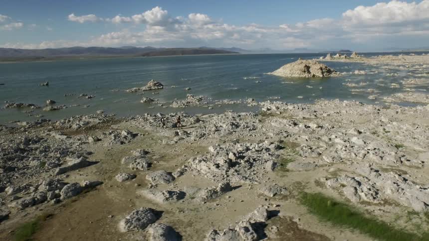 People walk on a rocky beach