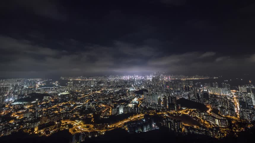 Traffic flows along major streets in sprawling city lit by lights at night