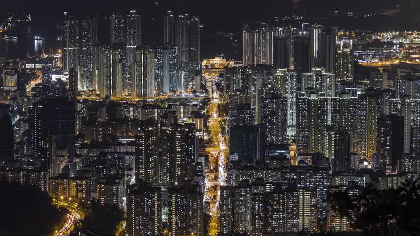 Skyscrapers and passing traffic light up a city at night