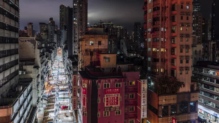 Aerial view of the city with tall buildings and people fill the market street at night