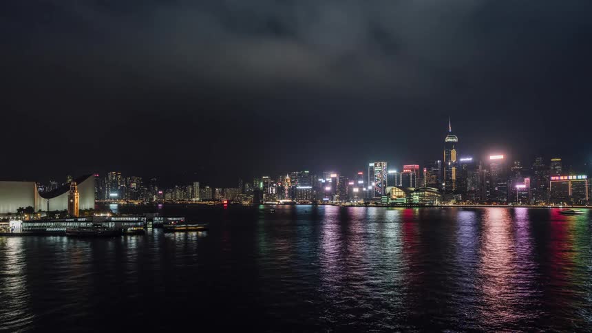 Time lapse of boats in the water in front of the city skyline