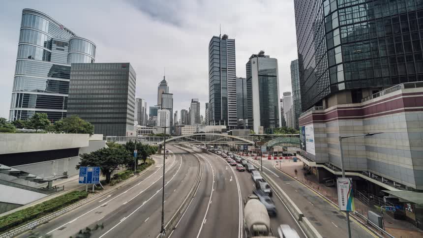 Traffic moves slowly along highway away from the city on a cloudy day