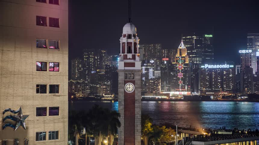 The clock tower and skyline of the city with illuminated buildings and skyscrapers at night