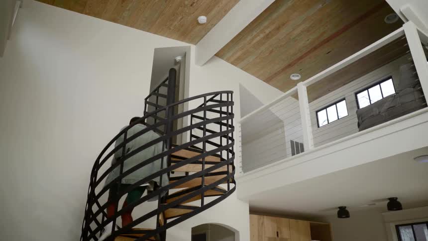 Black girl descends spiral staircase