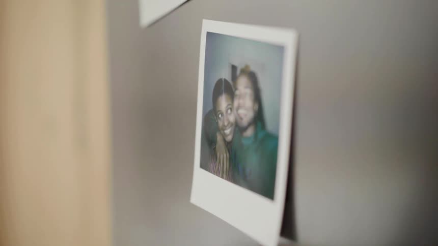 A black person fingers a picture stuck to a wall