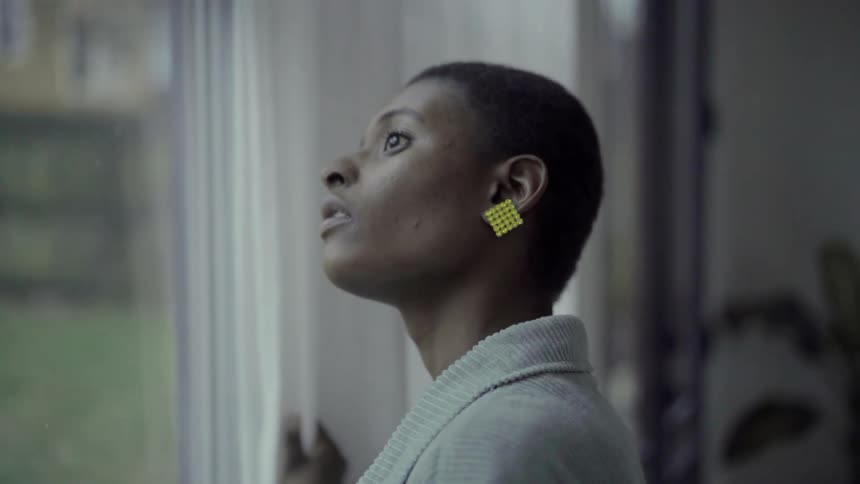 A woman walks to the window and looks outside