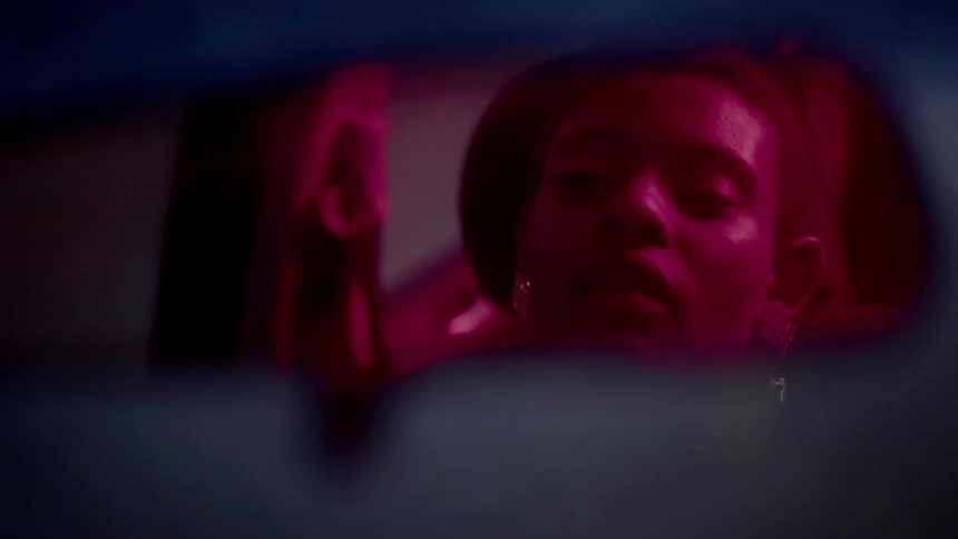 A woman sits in her car and looks beside her