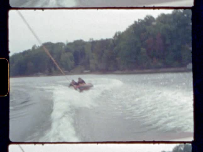Two people riding on a raft pulled by a boat
