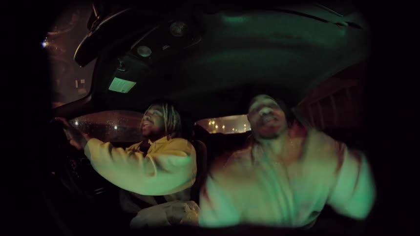 Two men in a car listening to music as one drives