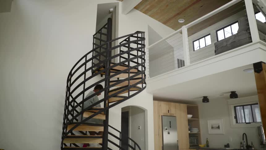 Black girl descends spiral stairs at home