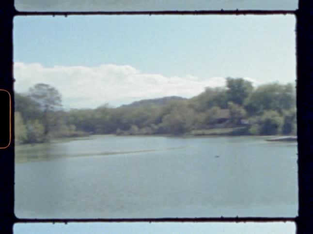 Footage of a lake next to a house is displayed