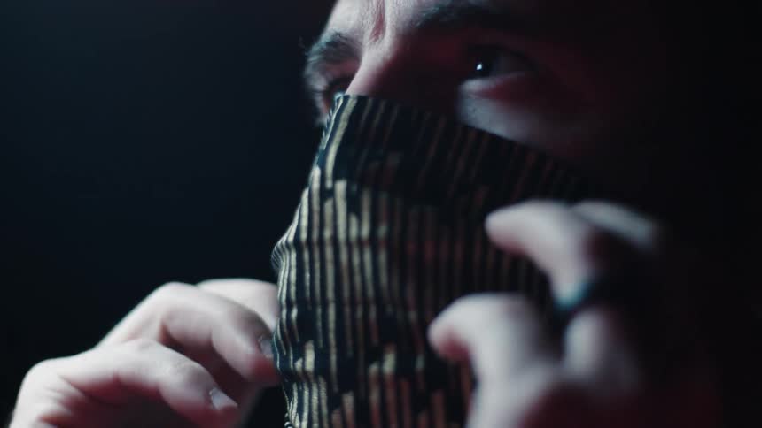 A man adjusts a fabric face mask