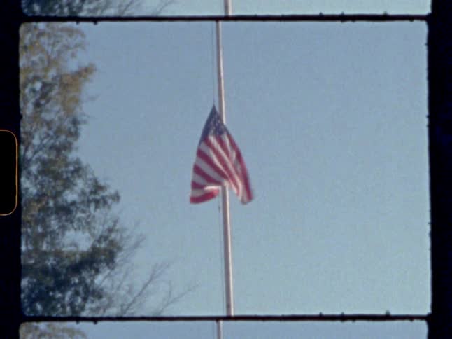 An american flag flying half mast on a pole