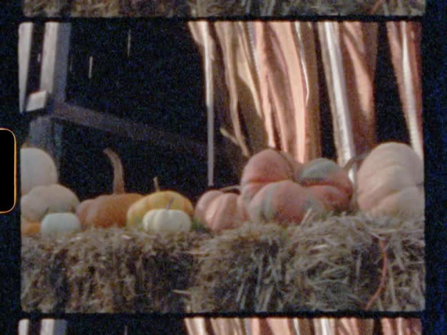 The pumpkins are stacked on the hay stacks by the farm