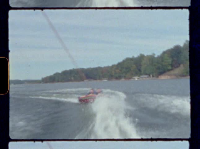 Two people ride on a raft being pulled in the water
