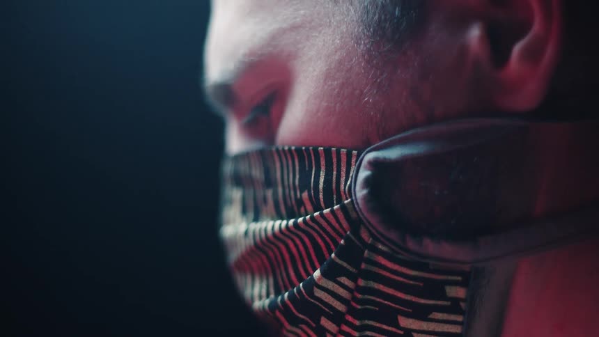 A man with a mask staring off into the distance