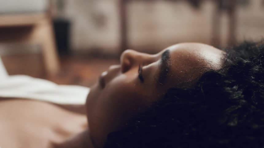 A black woman lies down