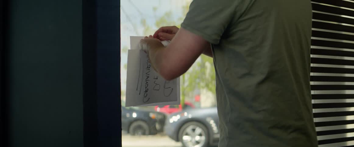 Store owner changes sign in store to announce delivery and takeout