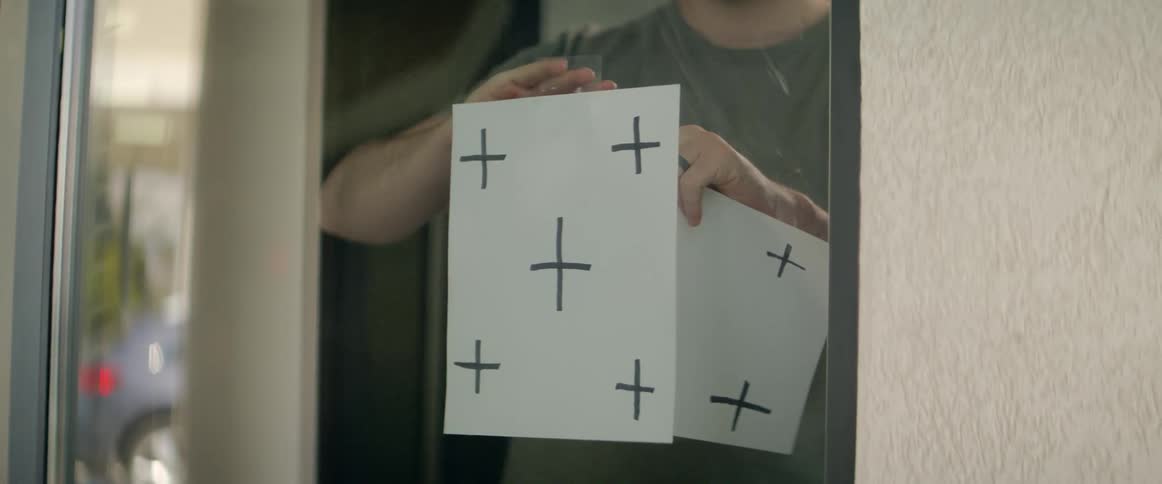 Man replaces one paper with another on window