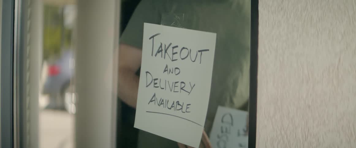 A man changes a sign on a restaurant door