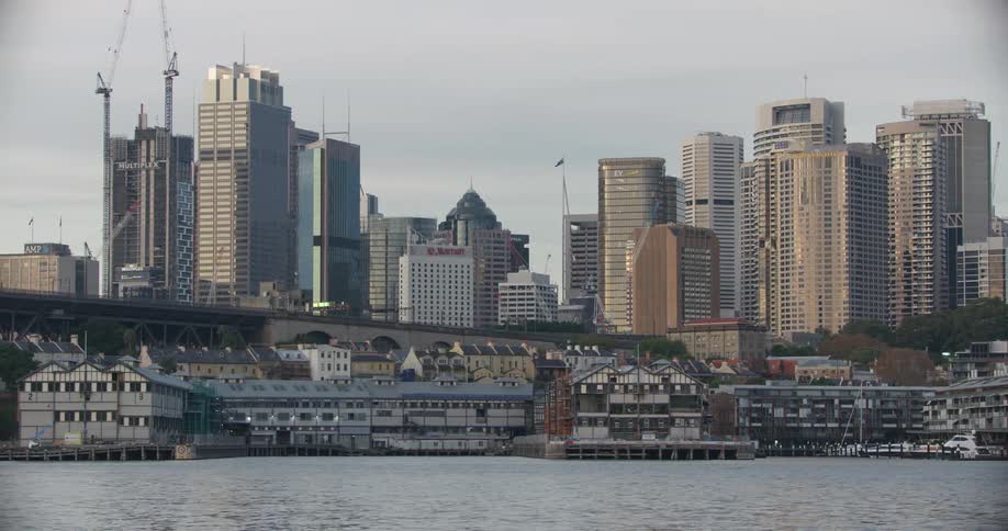 A coastal city with buildings and cranes in the background