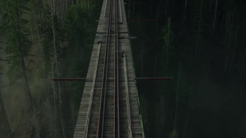 A drone flying over a railroad trestle