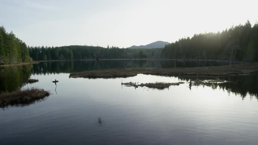Helicopter reflection on the face of a lake at sunset