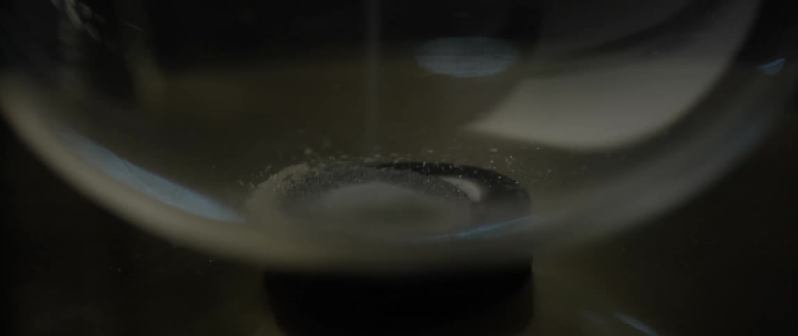 Sand falling to bottom of glass jar in a pile
