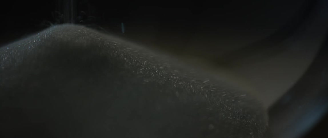 Sand being poured gathering into a mound