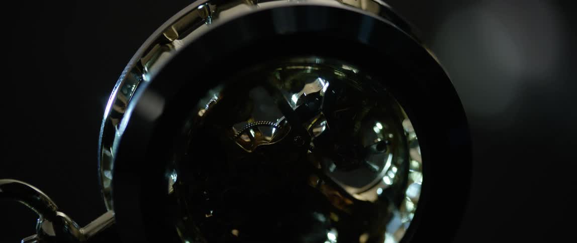 A pocket watch with gears turning inside