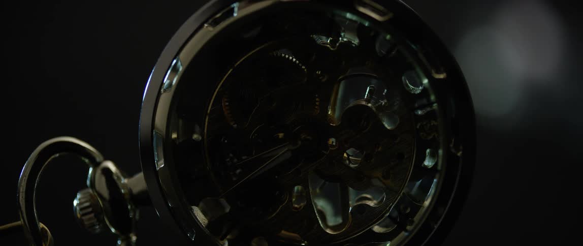 A pocket watch with gears turning inside