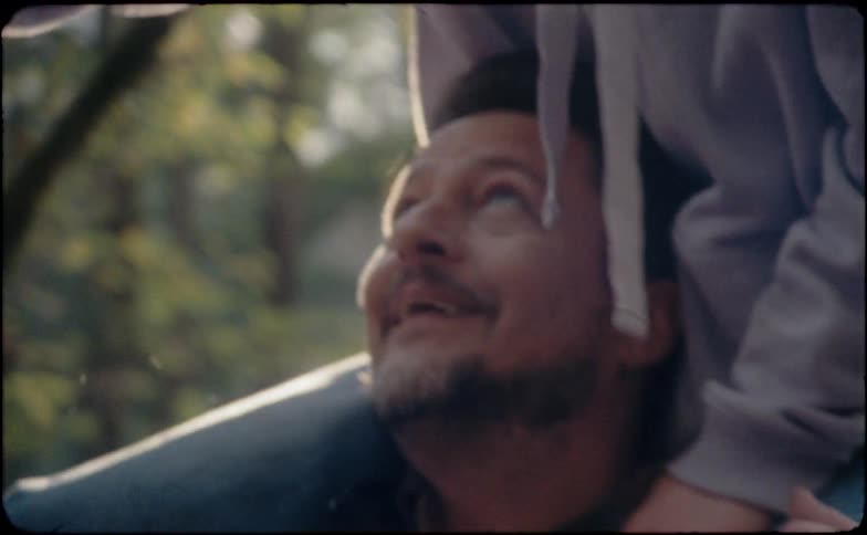 A man laughs with his daughter on his shoulders
