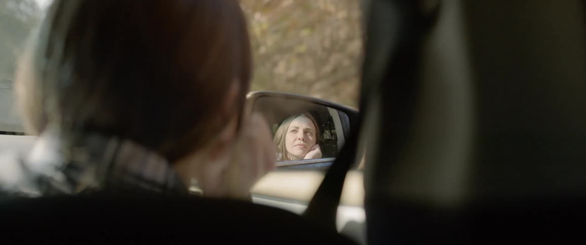 Woman looks out the window of the moving car