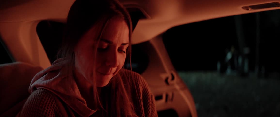 A woman sitting in a car talking and smiling