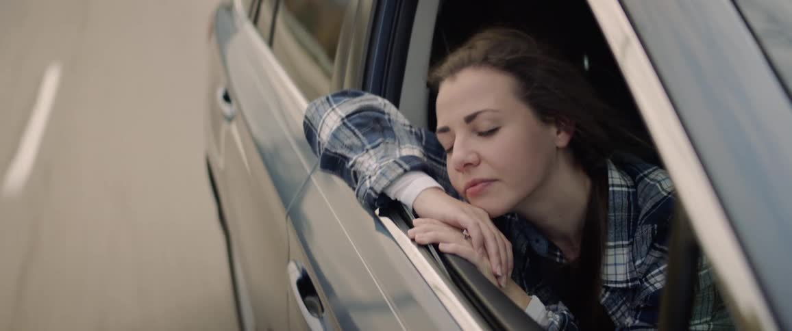 Woman looks out the window of the moving car