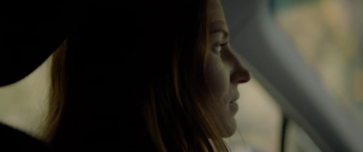 A woman drives while talking to an unseen person