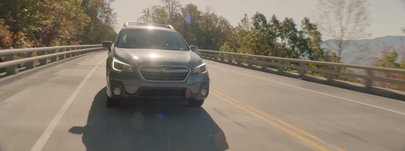 A sport utility vehicle drives down a rural two lane road
