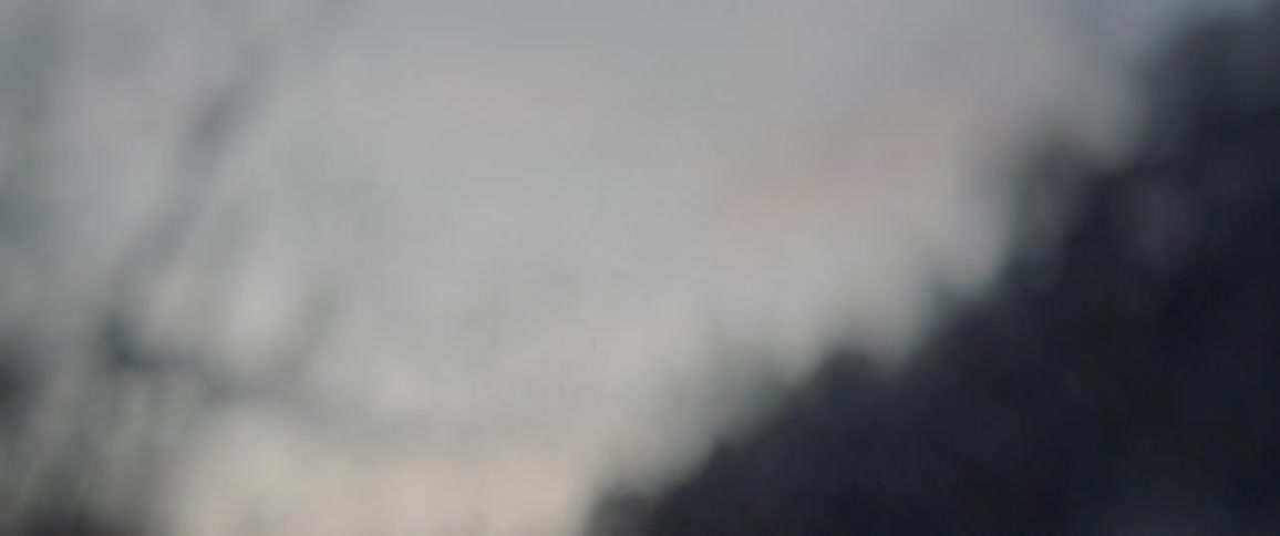 Smoke flows on air against wilderness backdrop