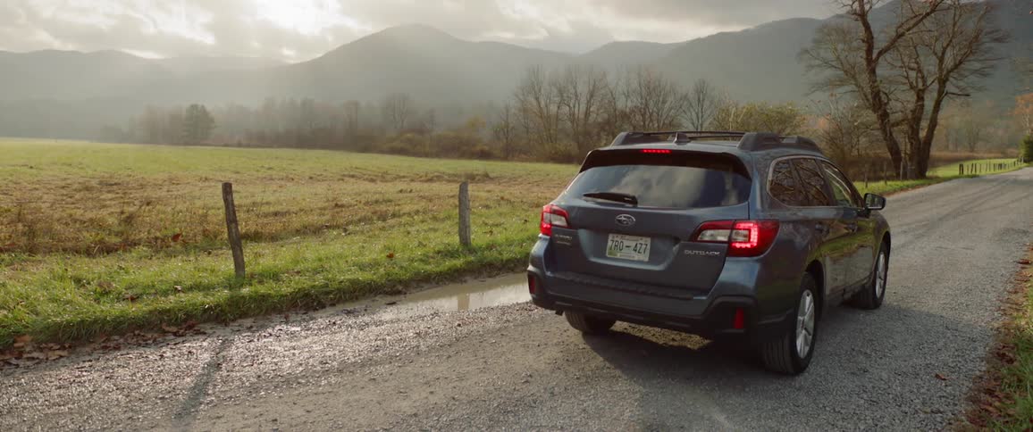 Car drives and stops on dirt road in the country side