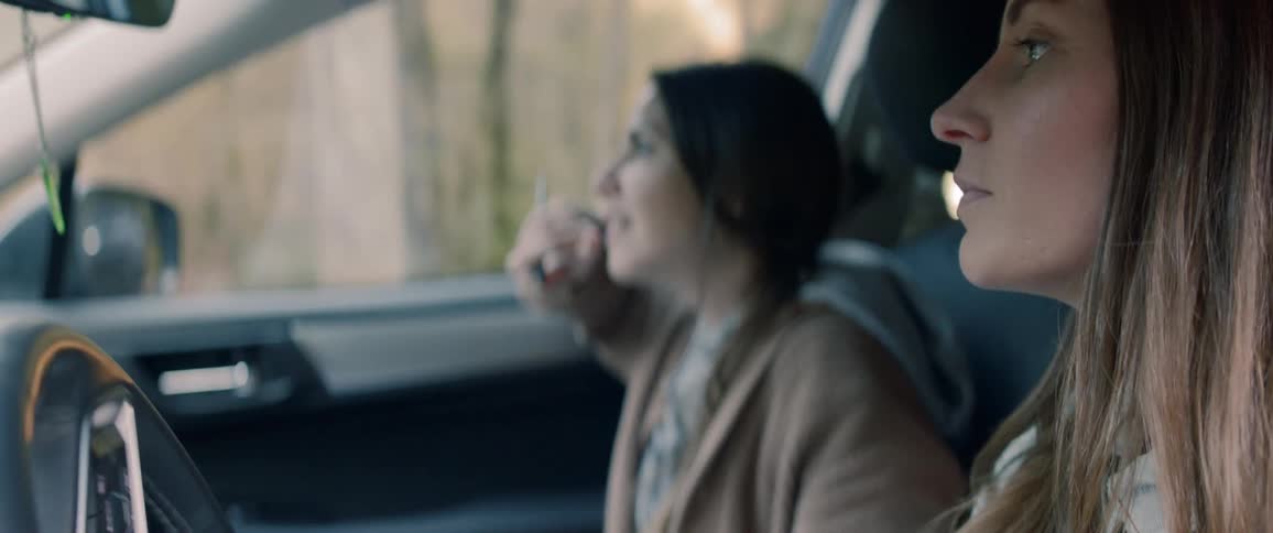 A mother and daughter look lost as they drive through a forested area