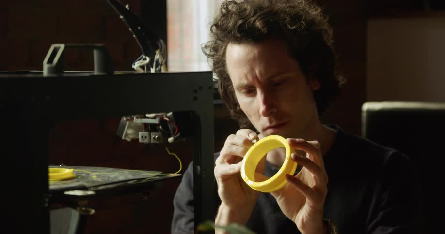 Man draws in a yellow circular object with apen
