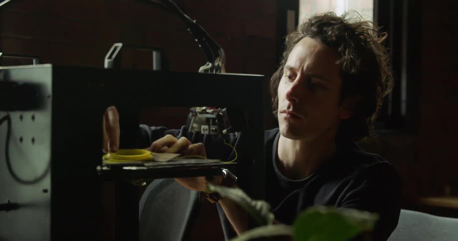 A young man takes some wire off of audio equipment