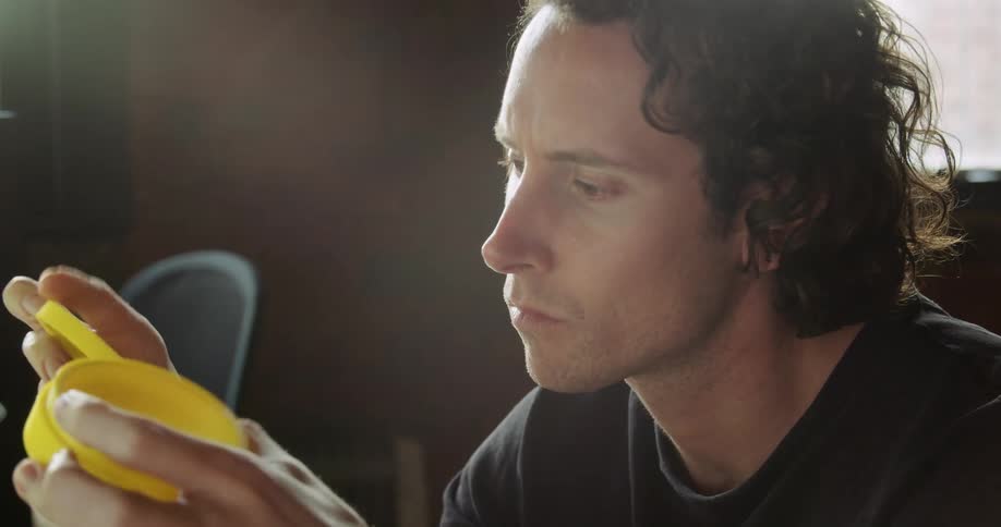 Man sitting in office examines yellow plastic part