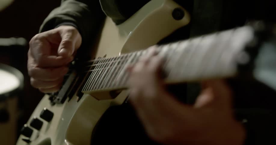 A man sits and plays the guitar