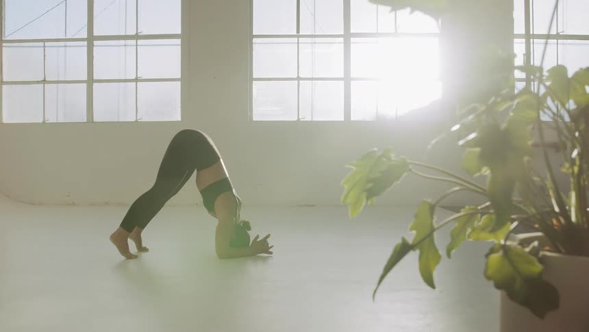 Woman practicing yoga poses in an empty studio