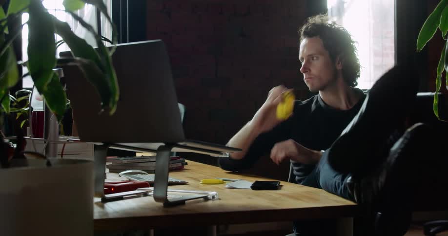 A man in an office is working at a computer workstation