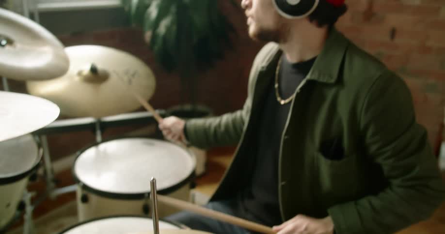 Male drummer plays drums and records the amount of time on his smart phone