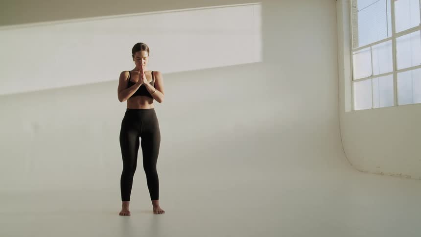 Female yogi practicing yoga alone in a studio