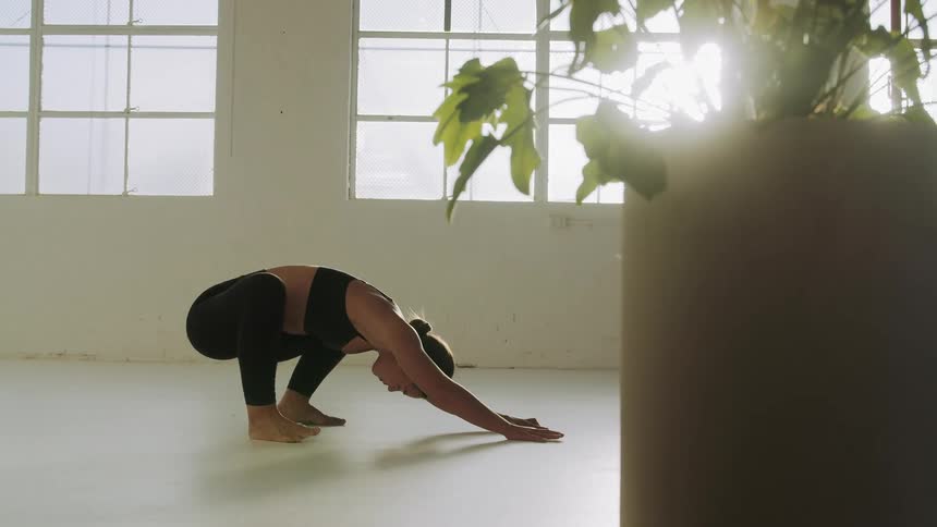 Brunette woman exercises in a room without furniture